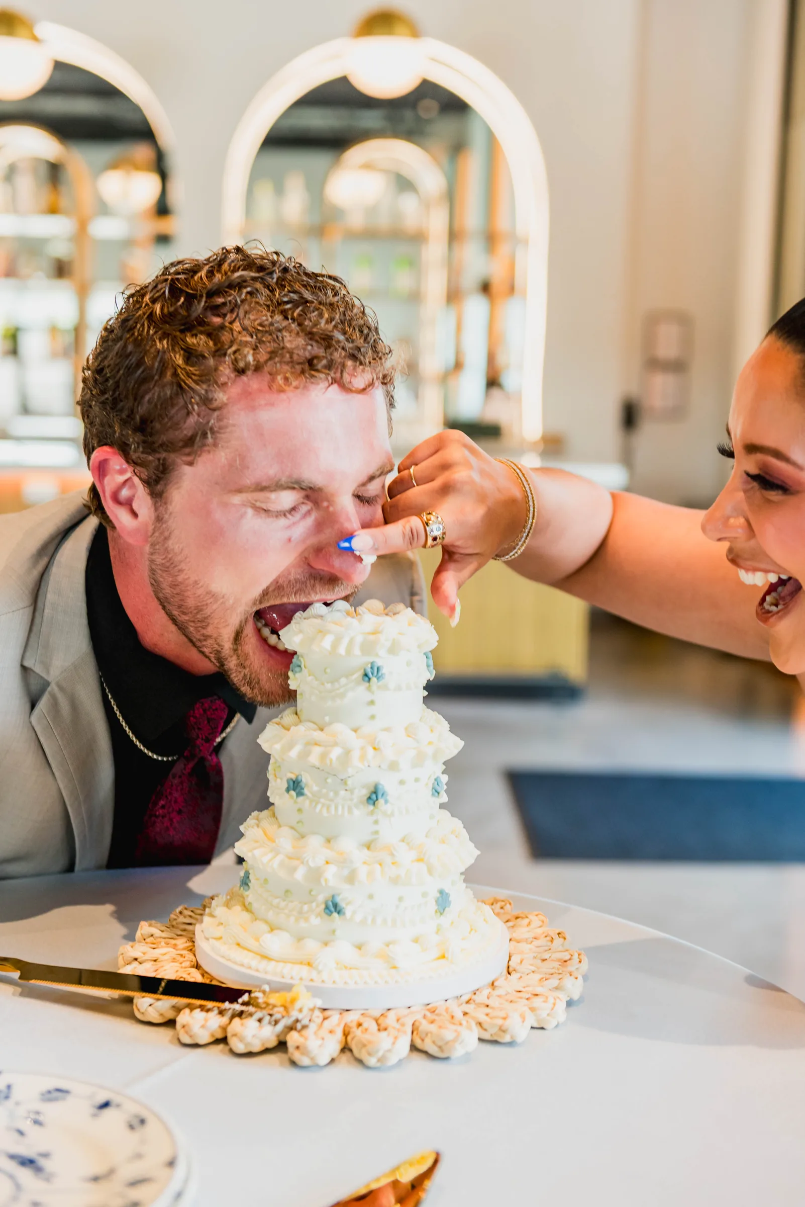Casal celebrando diante de um bolo de casamento