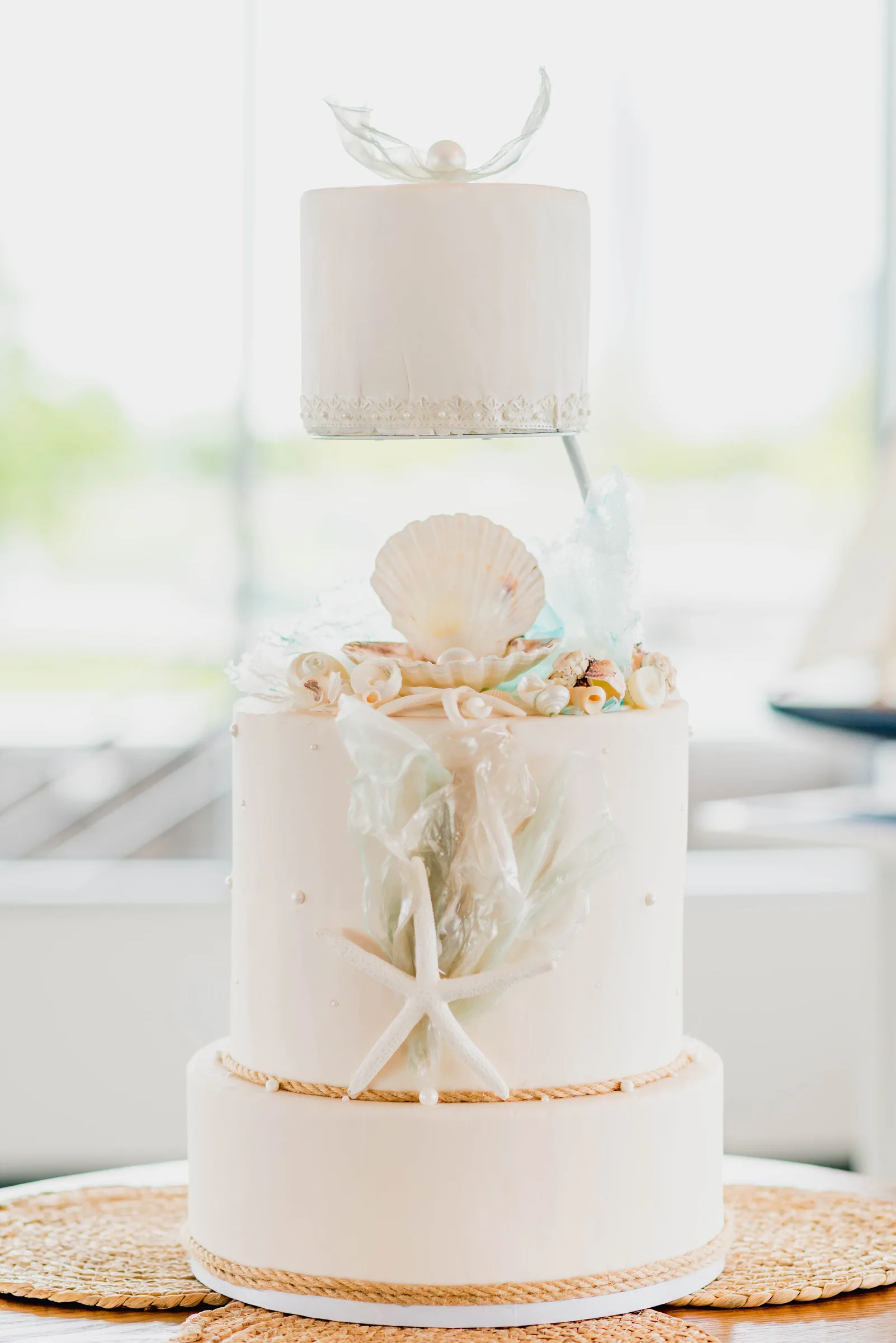 Bolo de casamento suspenso com conchas e estrela-do-mar