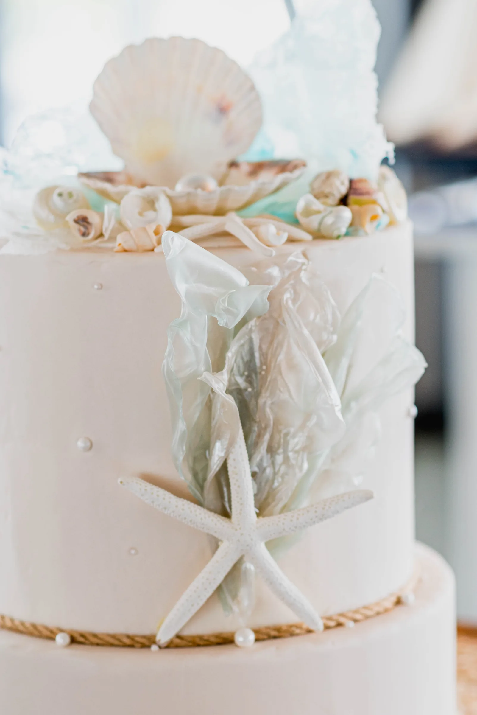Detalhe de bolo de casamento com conchas e estrela-do-mar